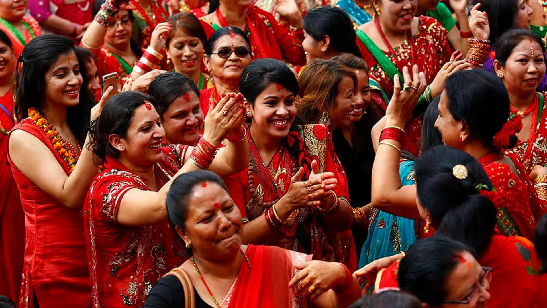 women dancing during teej wearing red sari