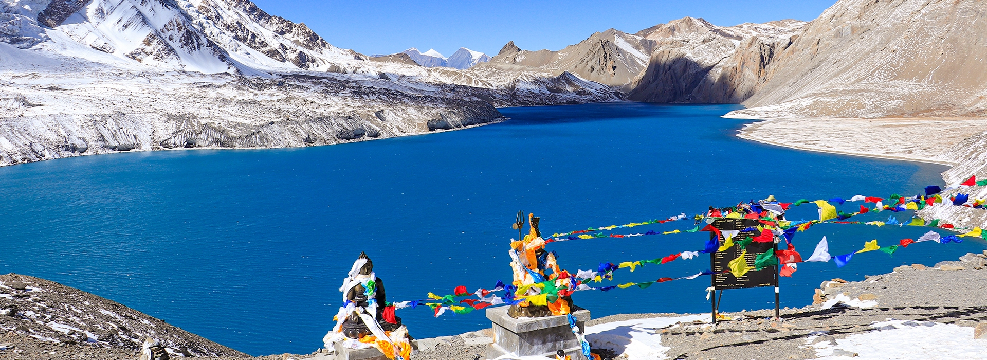 Tilicho Lake, blue water & Buddha statue from Tilicho Pass