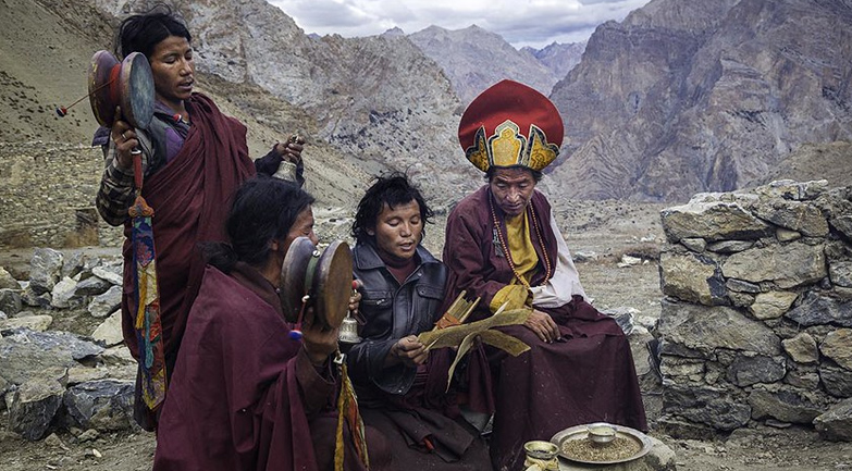 The image likely depicts a Tibetan Buddhist ceremony or ritual taking place in the mountainous regions of the Himalayas, possibly involving monks or lamas performing a traditional religious observance.