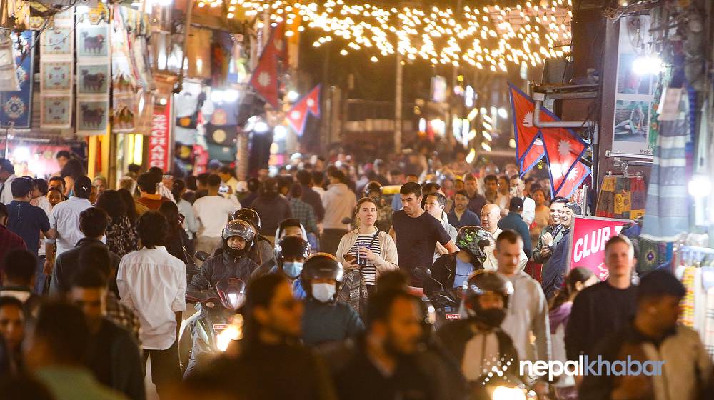 people walking in the street, dim lights around thamel.,Cozy evening
